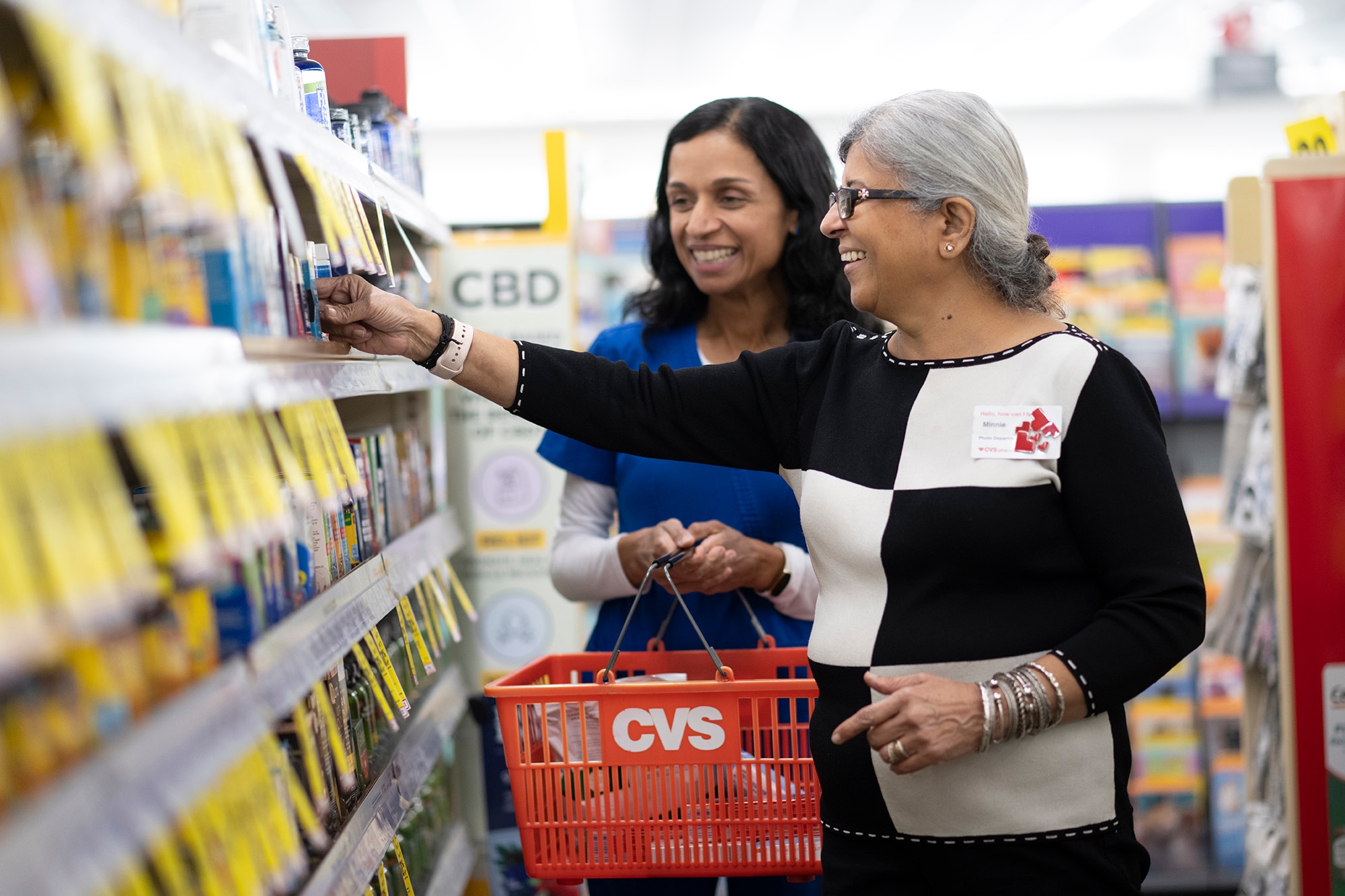 Minnie assists customer Sandhya Harpavat in an aisle. They are both smiling.