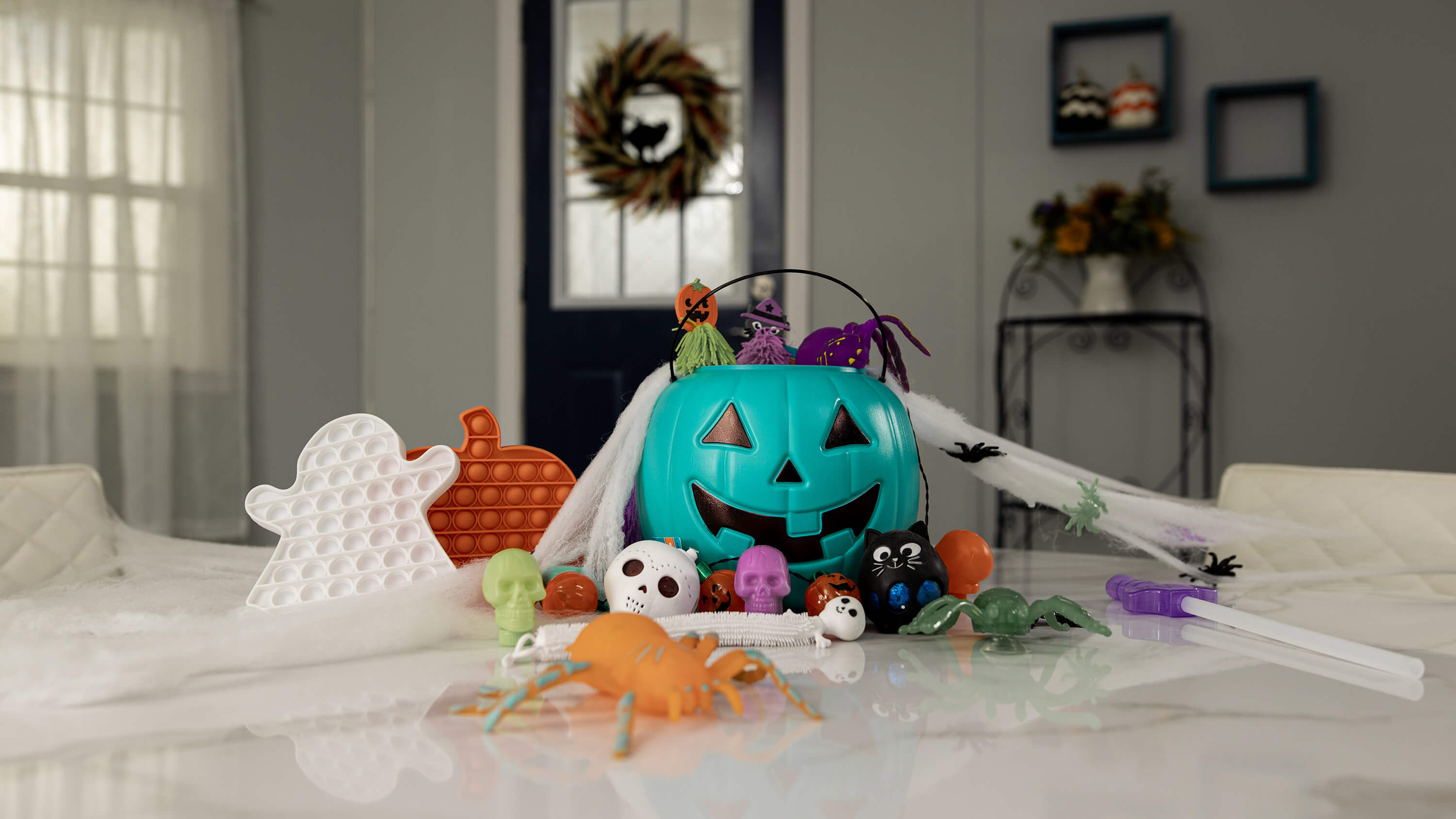 A teal pumpkin and other Halloween decorations on a kitchen table