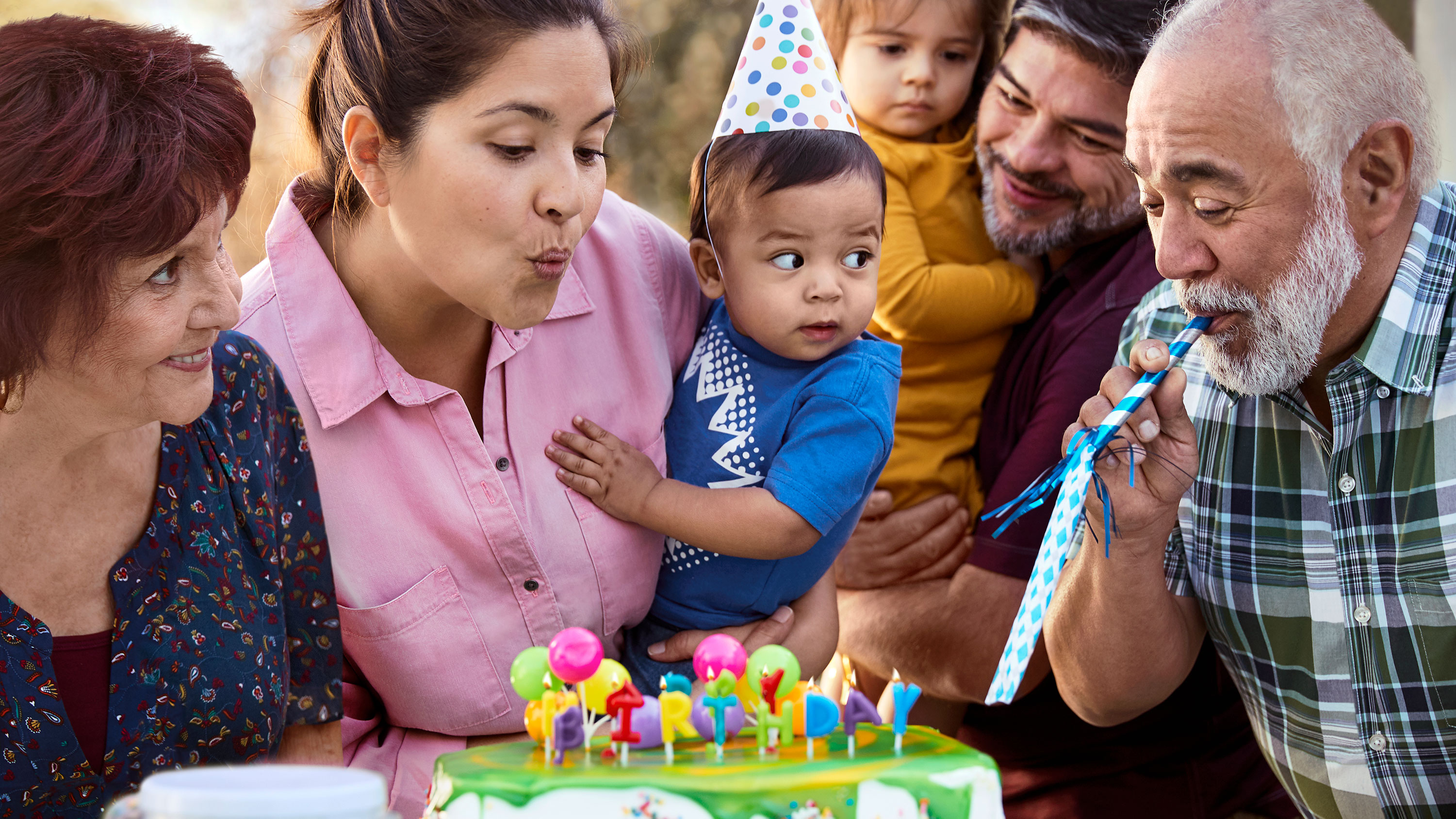A Hispanic family shown celebrating a small child's birthday