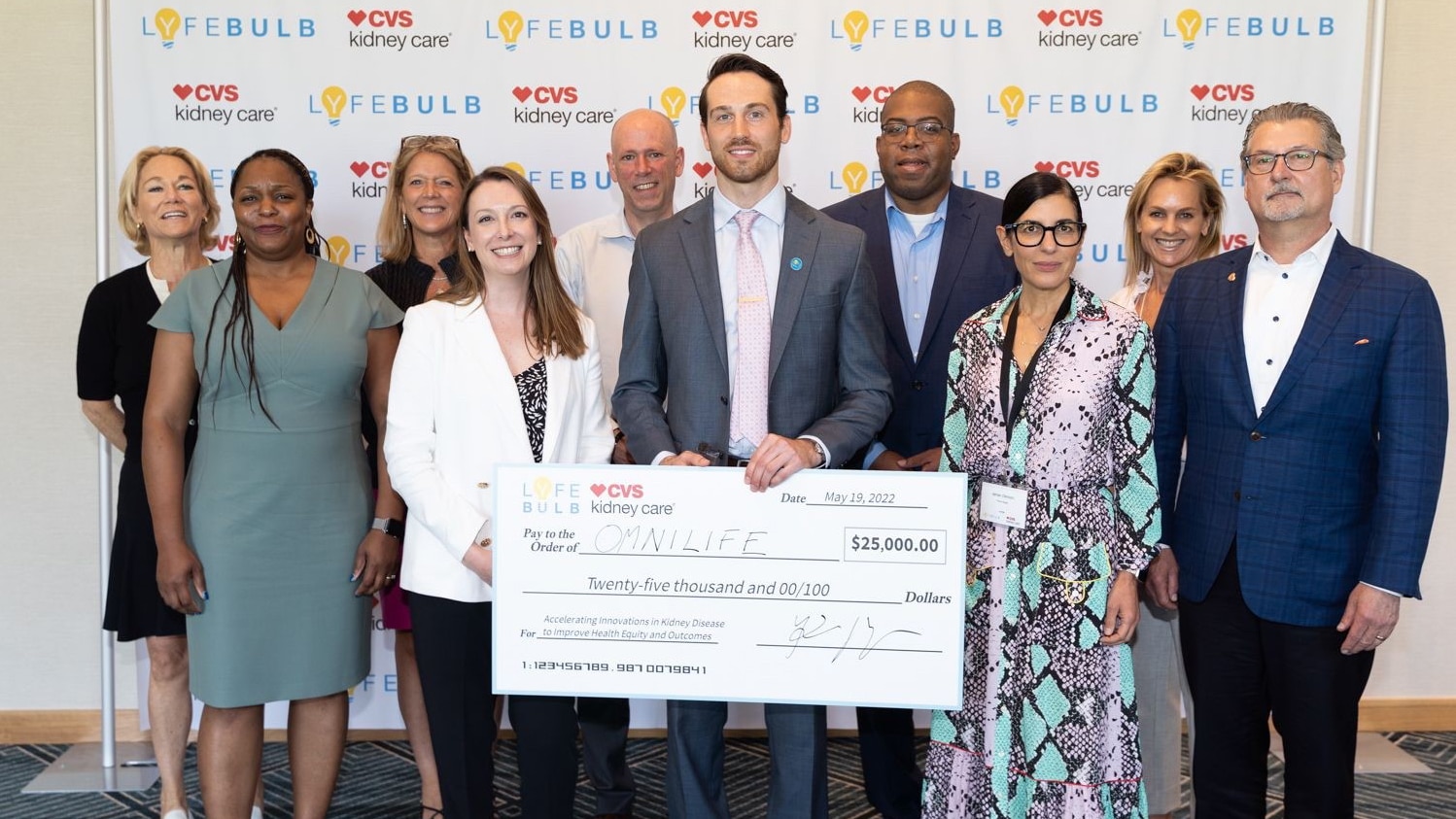 Omnilife team receiving giant check award at the 2022 Lyfebulb–CVS Kidney Care® Innovation Challenge