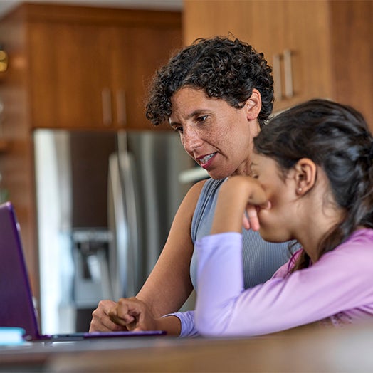 Mother and daughter looking at a laptop together