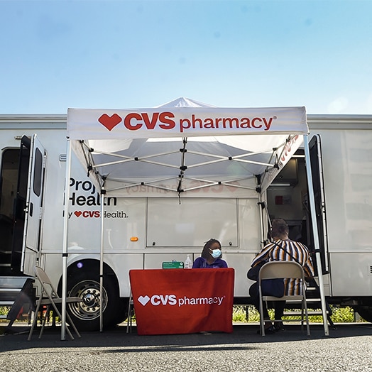 Two people talking at a CVS Pharmacy table at a Project Health event