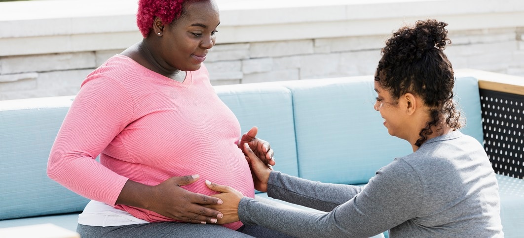 A pregnant person sitting with their doula