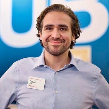 Man with nametag smiling in front of HealthHUB