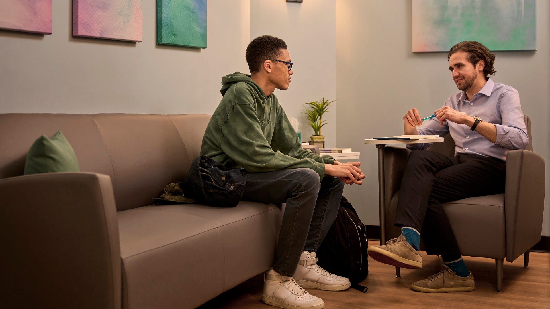  A man meets with a mental health counselor in an office. 