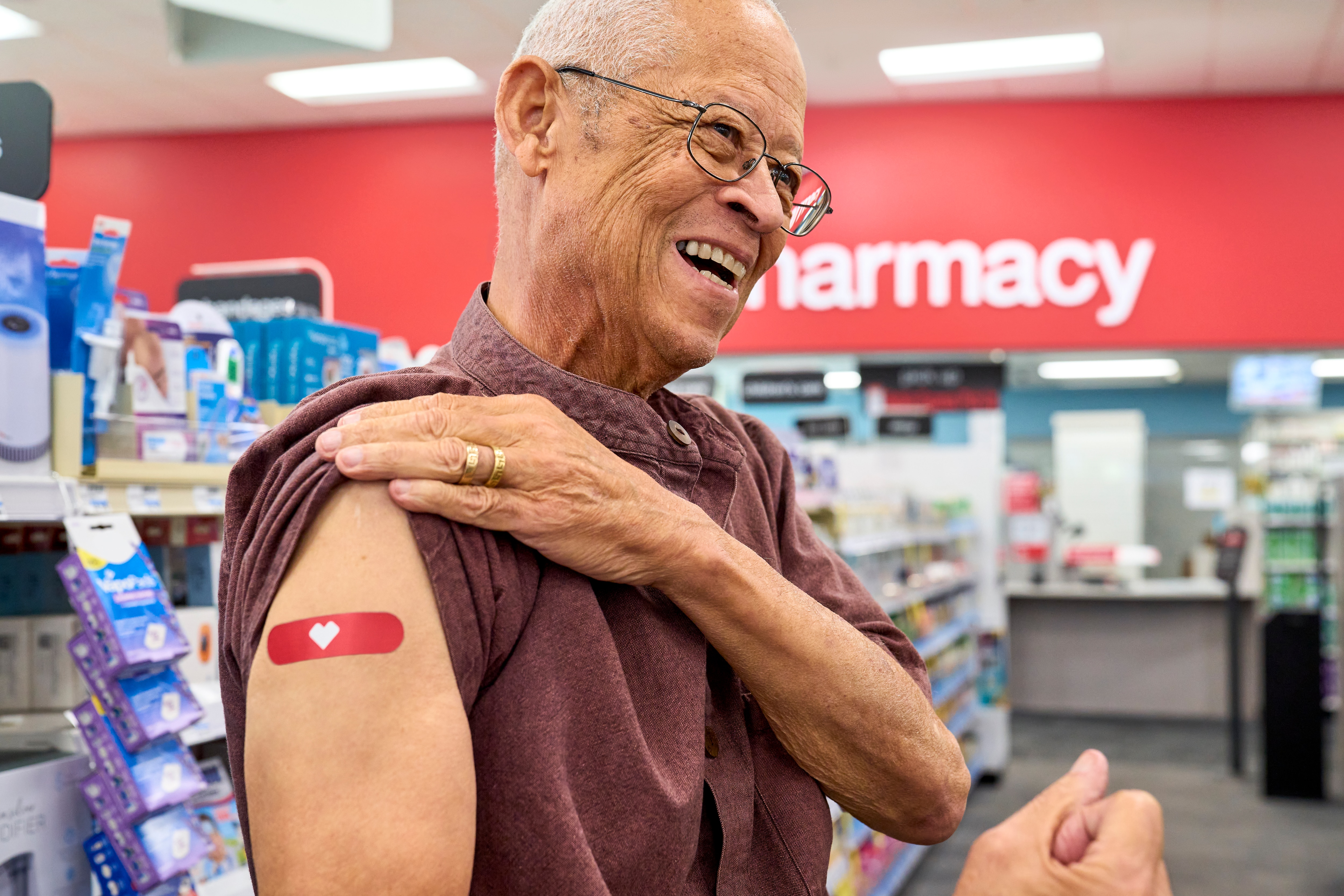 An older person who just received a shot from a pharmacist