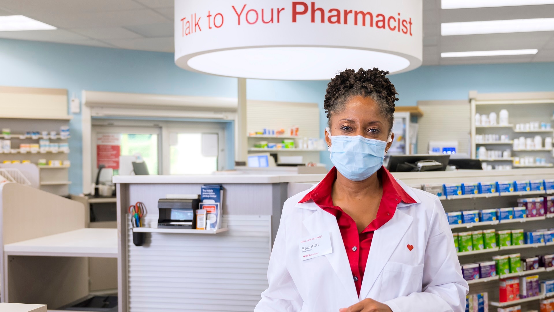 CVS pharmacist with mask on within a CVS Phamarcy location
