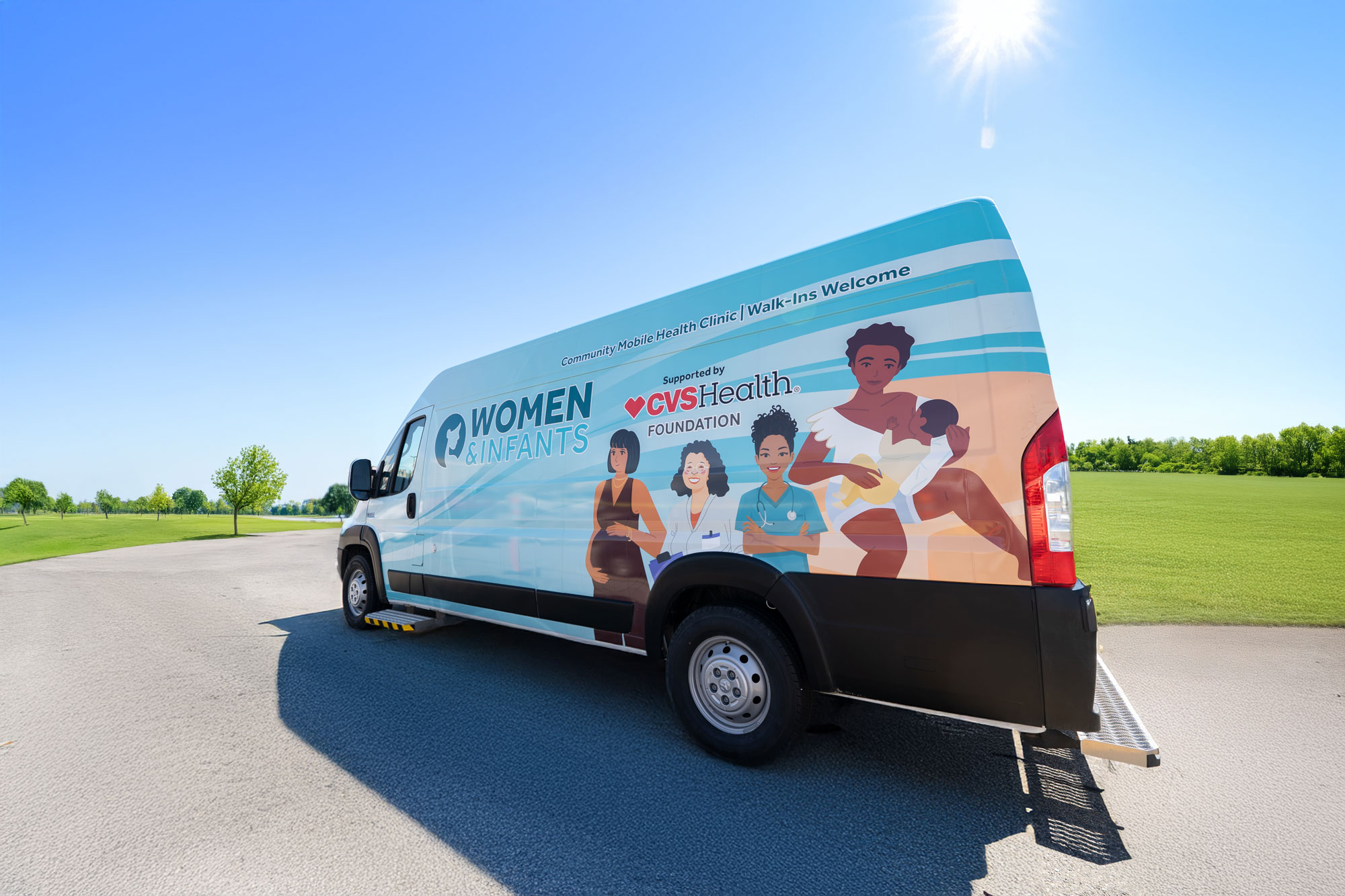 A mobile health clinic van parked outdoors on a paved road, featuring ‘Women & Infants’ graphics and CVS Health Foundation branding on the side, with illustrated figures and green open fields in the background.