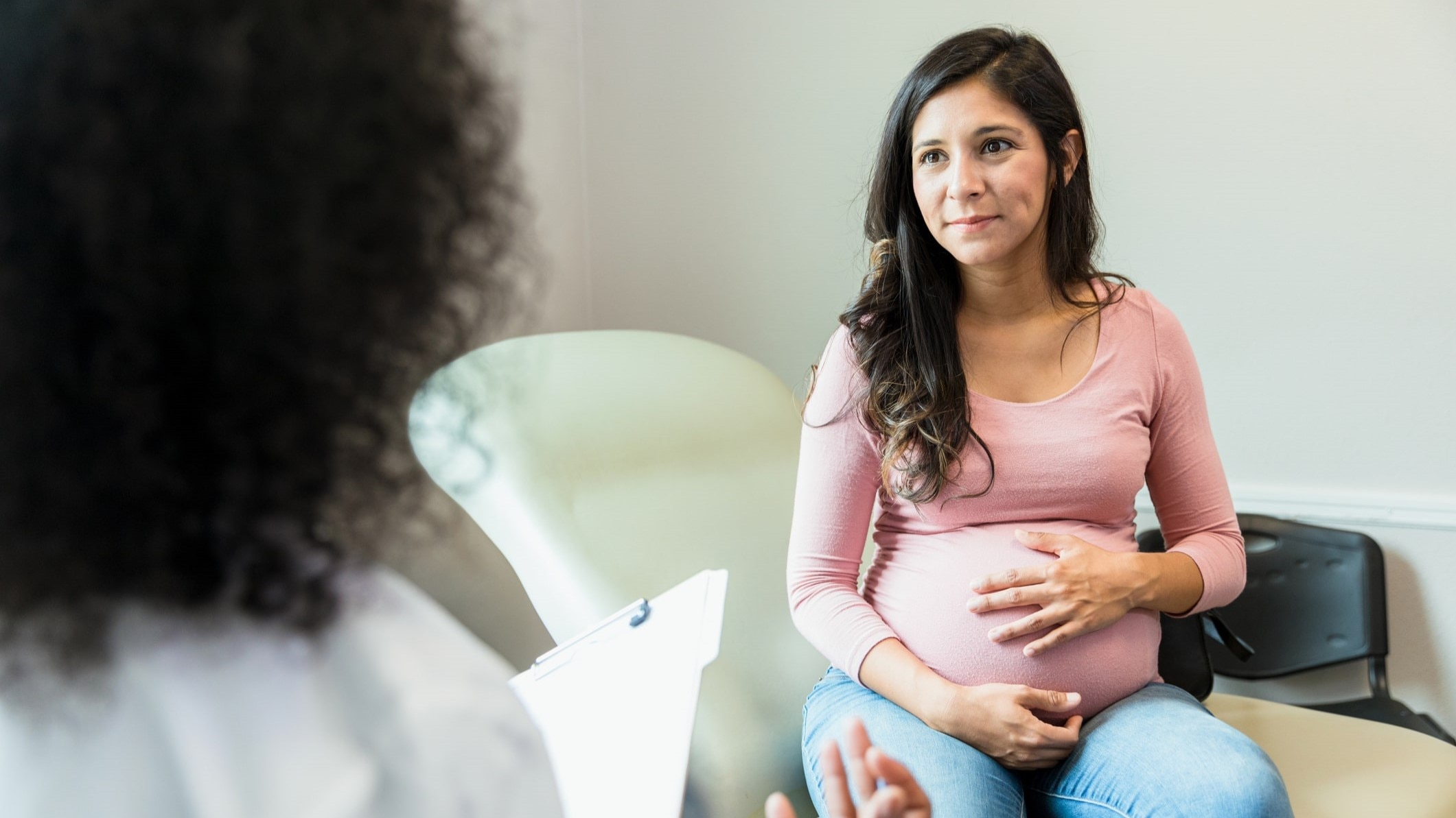 A pregnant person speaking with their doctor