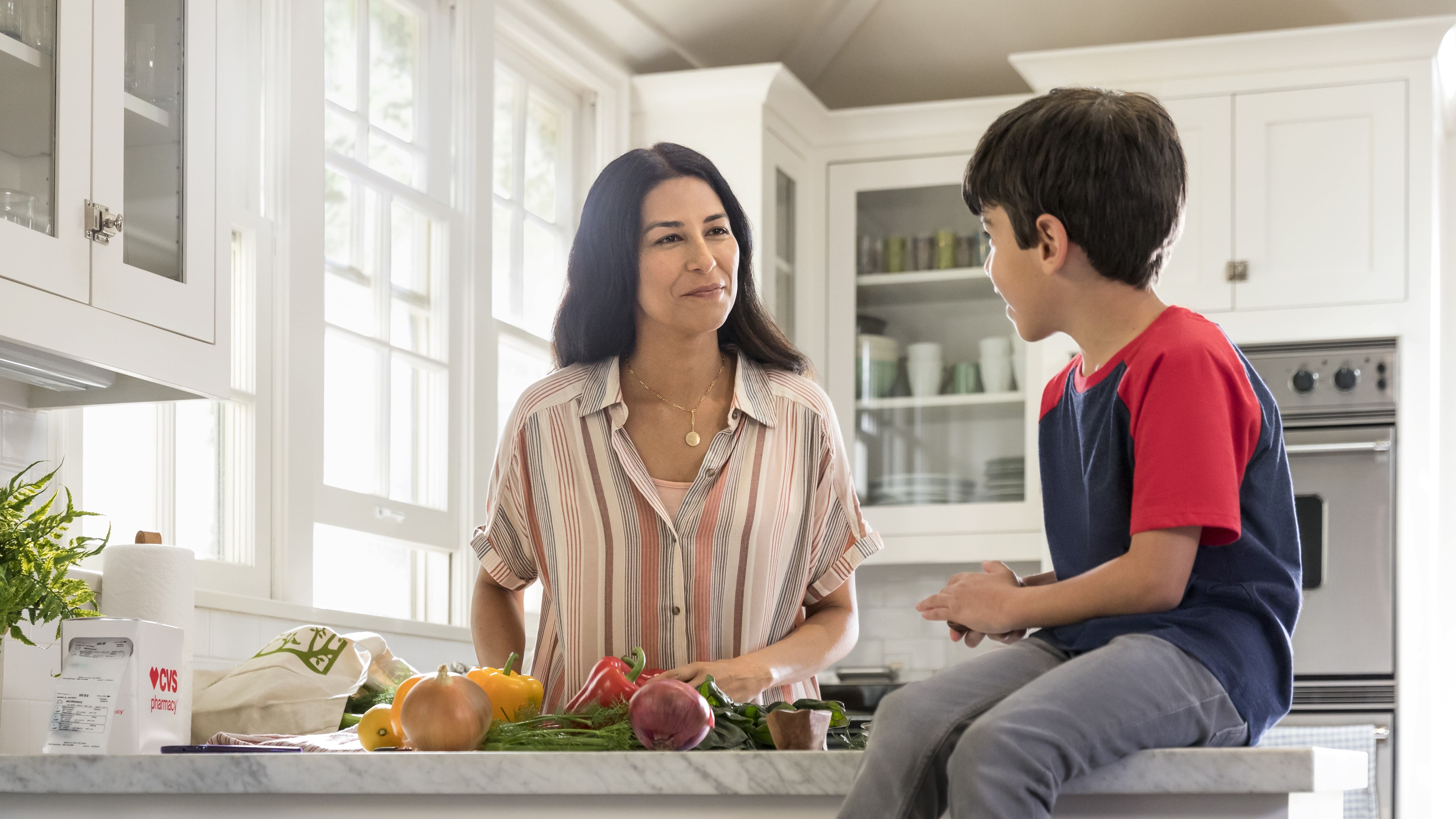 Woman talking to boy in kitchen