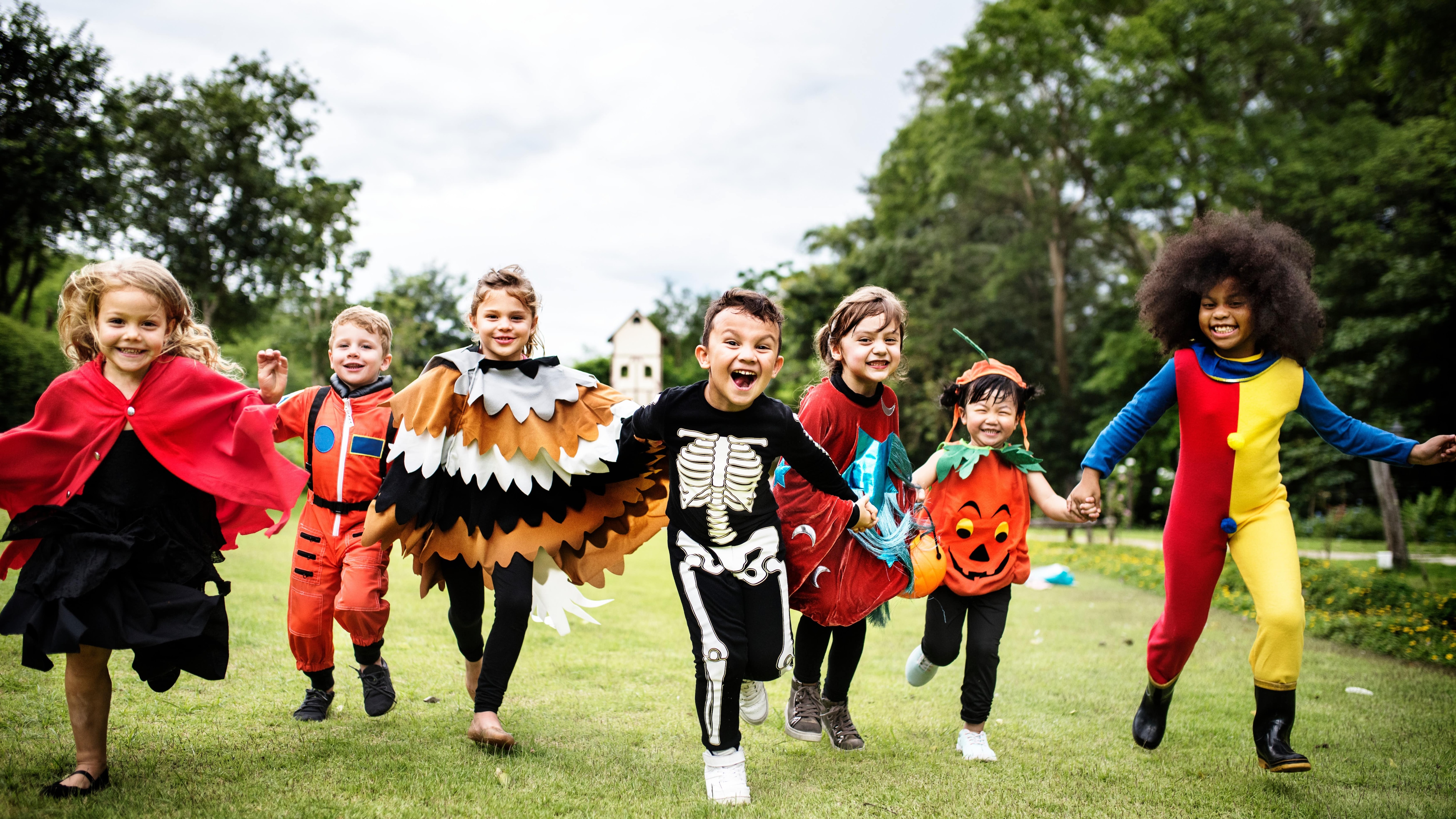 Children in halloween costumes running in a field