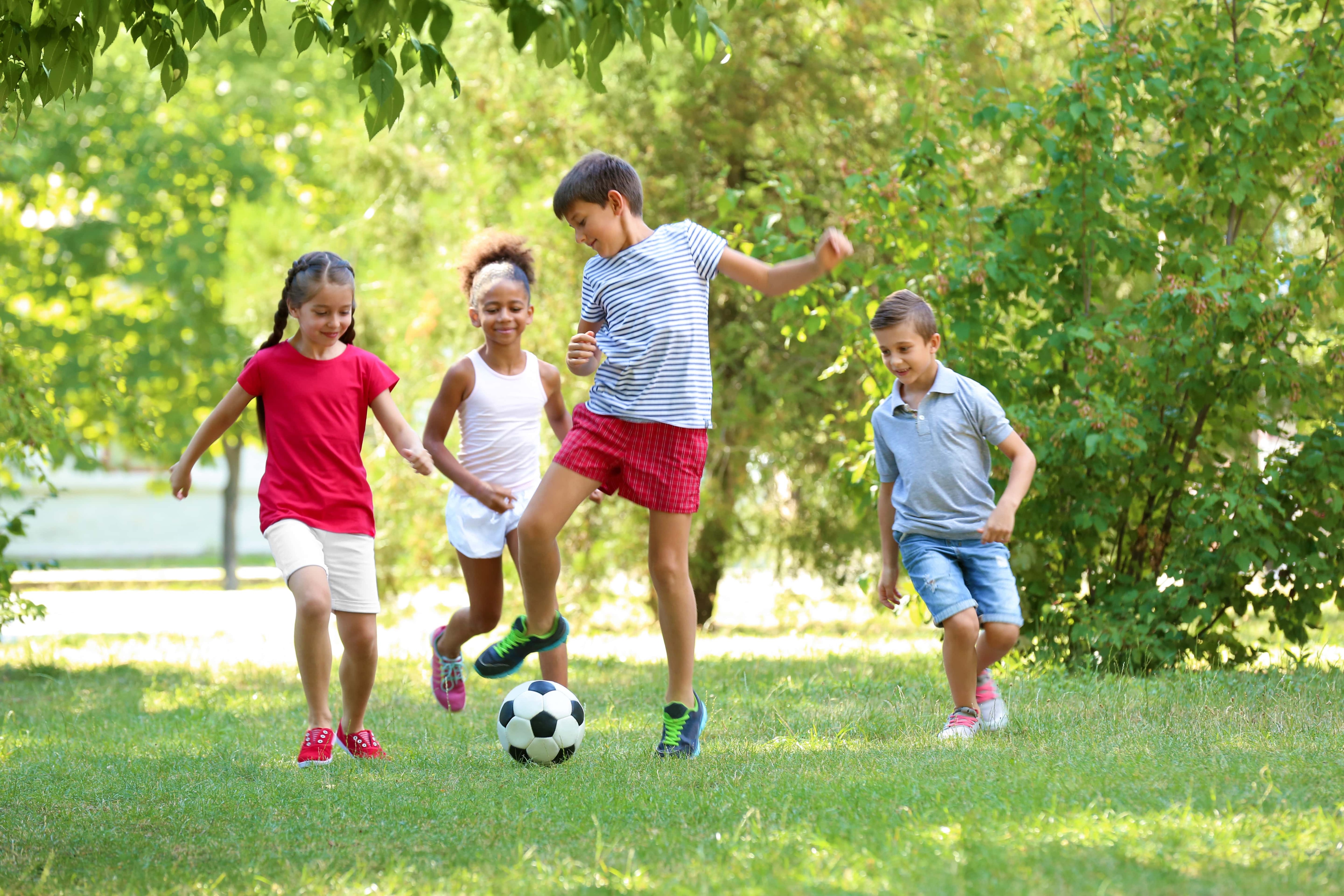 Children playing soccer in a park