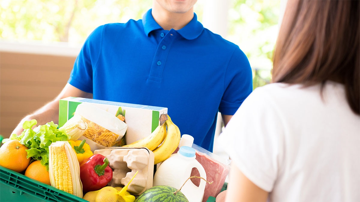 A man delivering a crate of food