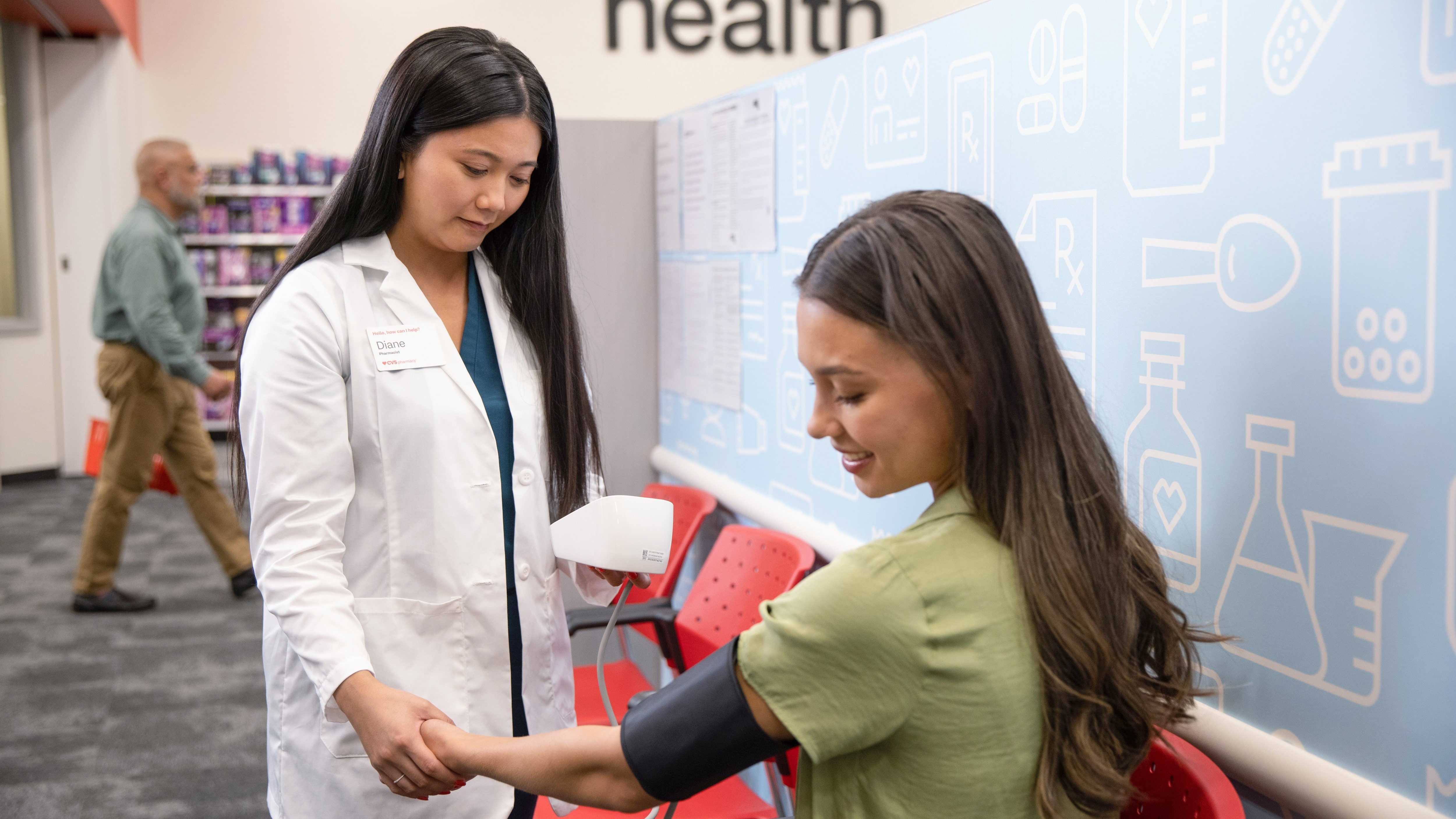 A pharmacist taking a customer's blood pressure