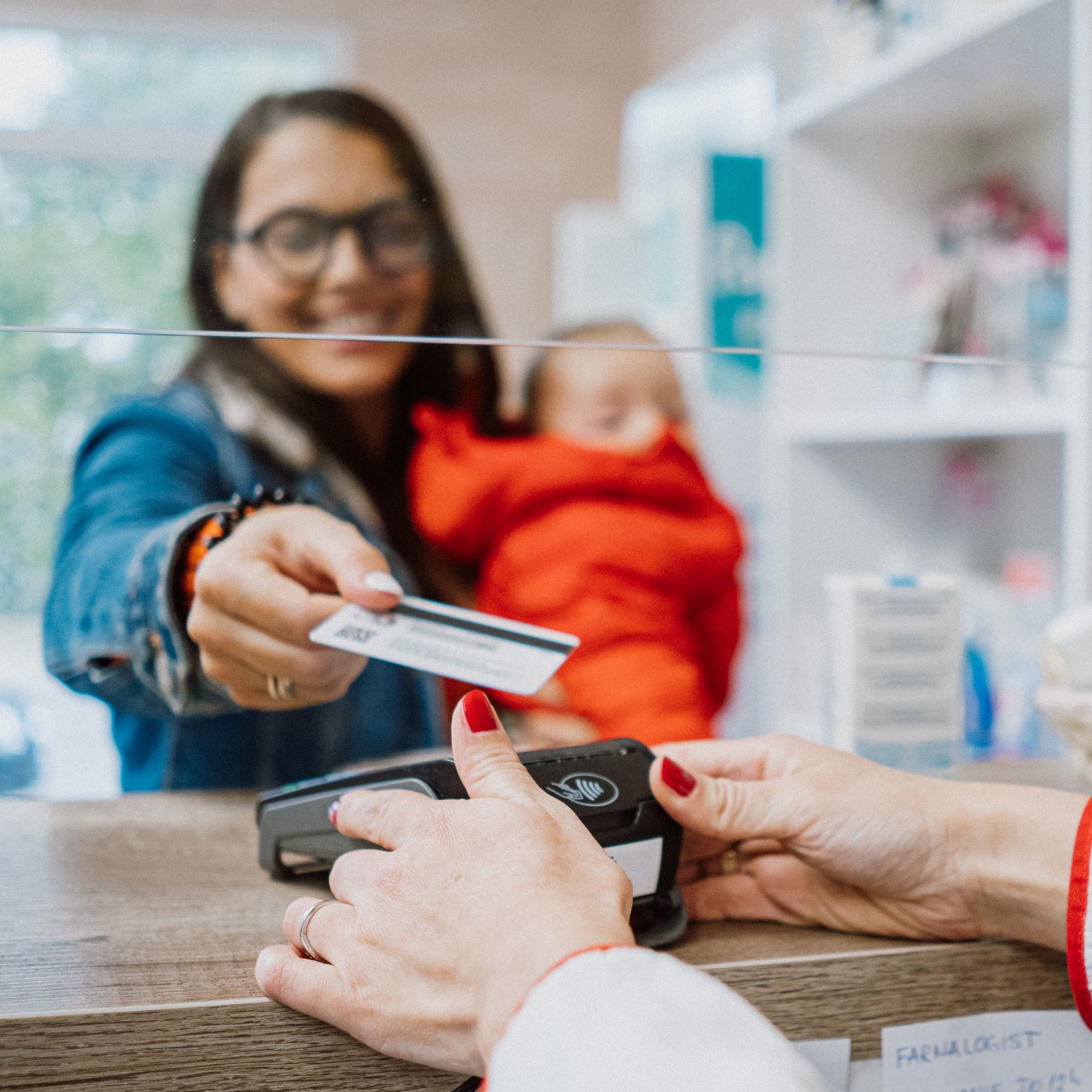 A woman paying for her medication at a pharmacy