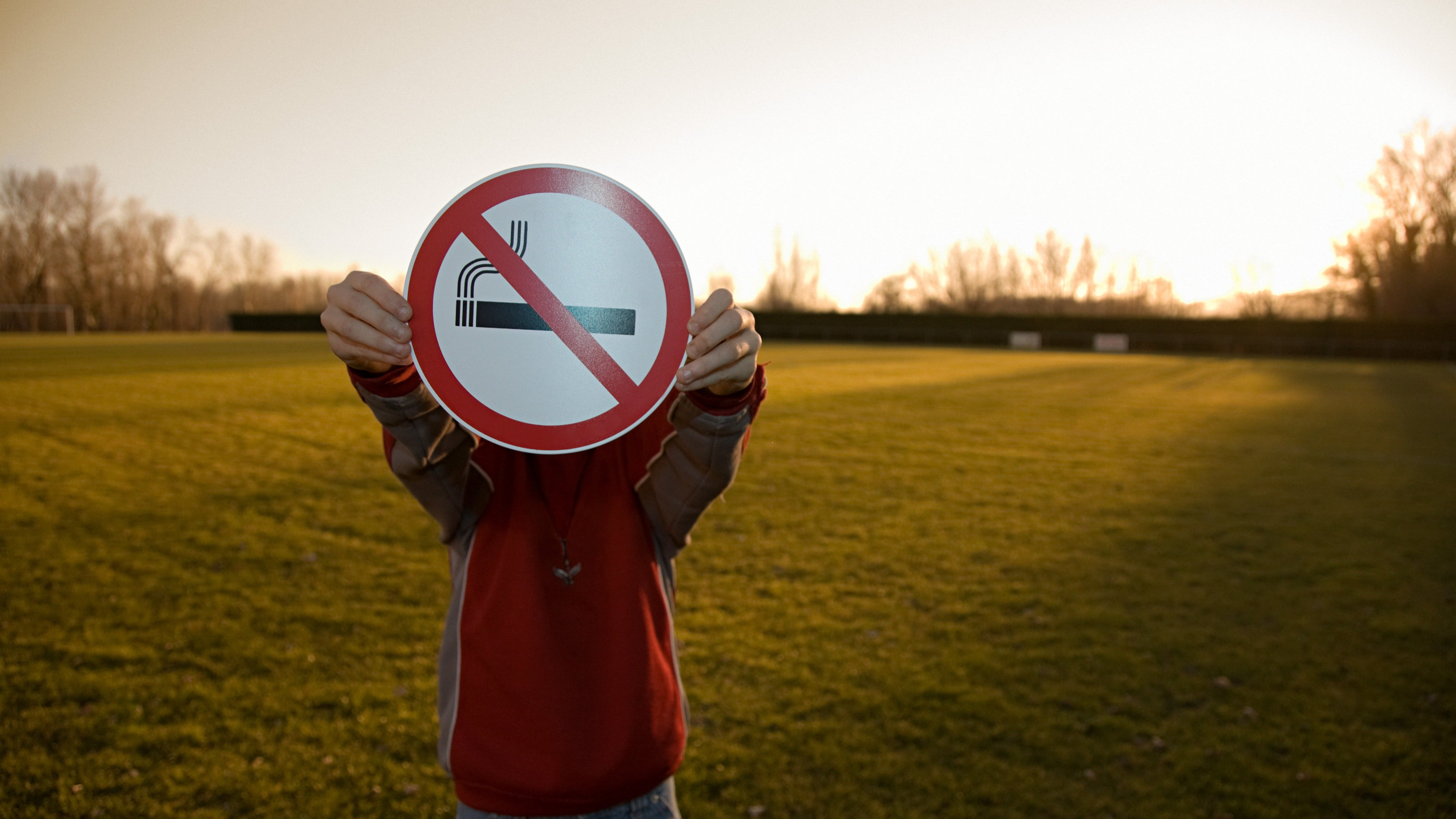Person holding a no smoking sign