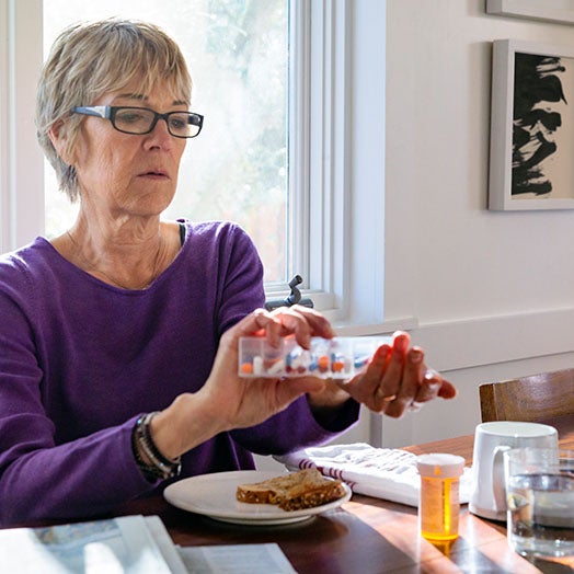 Woman taking medication with breakfast