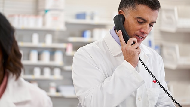 Male pharmacist on phone at pharmacy