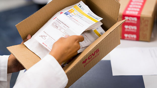 Pharmacist placing prescription refill into box