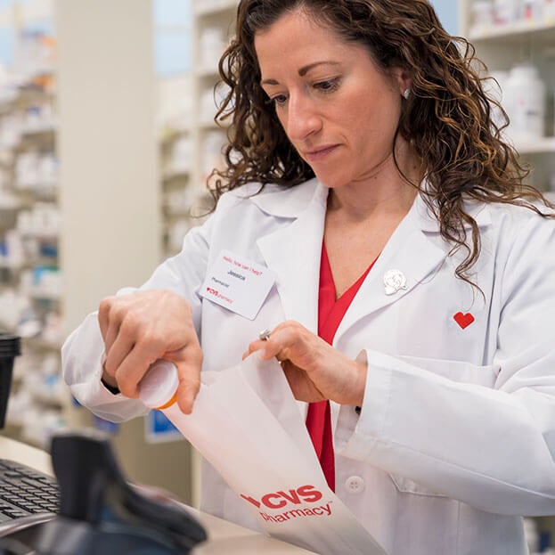 CVS pharmacist putting prescription in bag