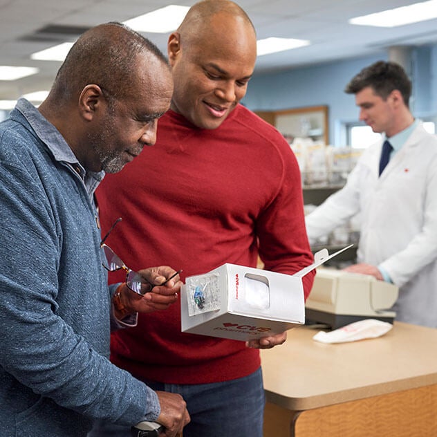 Two patients reviewing prescription information at pharmacy