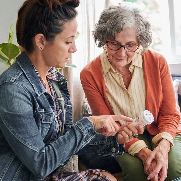 Two women reviewing prescription information on CVS pill bottle