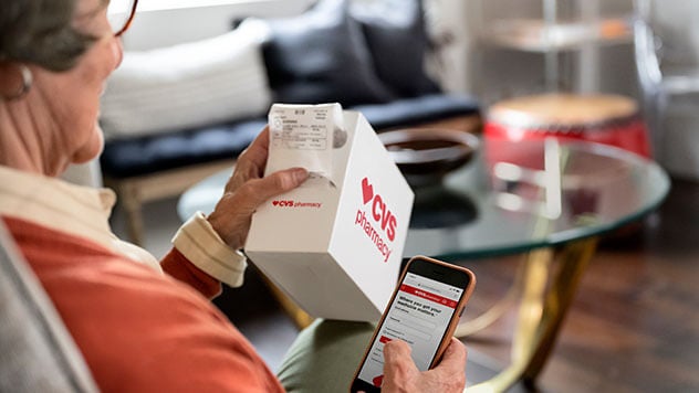 Female refilling CVS SimpleDose prescription service on cellphone