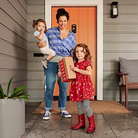 Mother with two children on front porch with package delivered from CVS