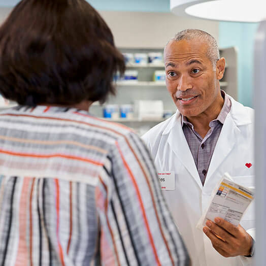 Pharmacist distributing prescription to patient at CVS Pharmacy