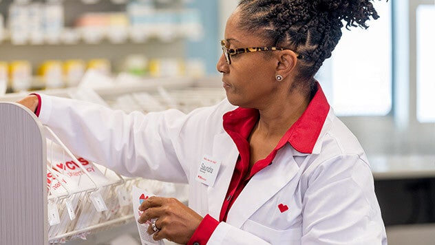 CVS Pharmacist filling medications at pharmacy