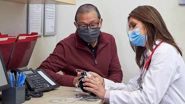 Female medical professional assisting male patient
