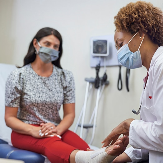 Woman's injured foot being examined by a fenale medical professional
