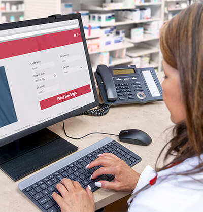 Female pharmacy professional searching on a desktop computer