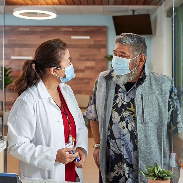 Male and female having conversation wearing surgical masks