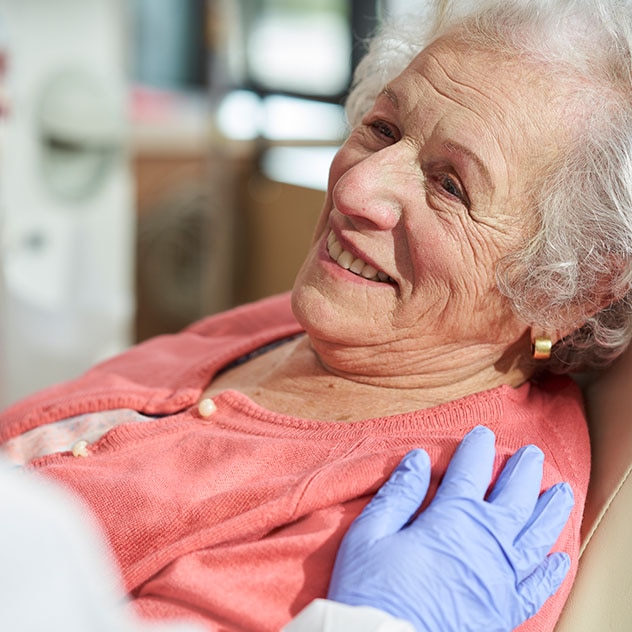Medical professional comforting older female patient