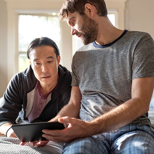 Two males looking at tablet together