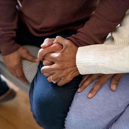 Couple on couch holding hands