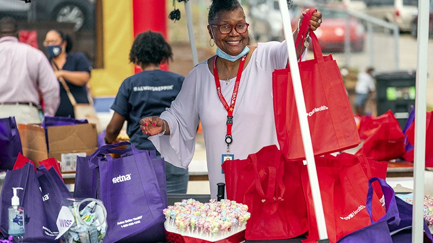 Woman handing out CVS Health and Aetna bags