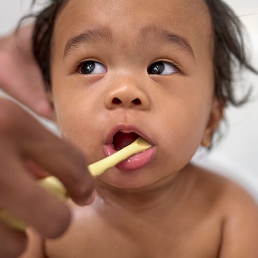 Parent brushing childs teeth