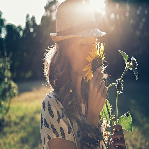 Woman smelling a flower in a field