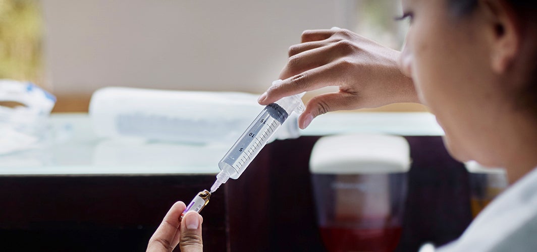 Medical professional with vial and syringe