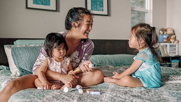 Mother and two daughters sitting in bed