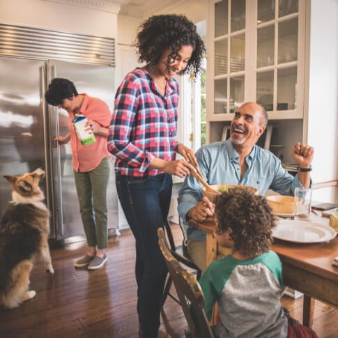A family is seen serving a dinner meal in their modern-looking kitchen.