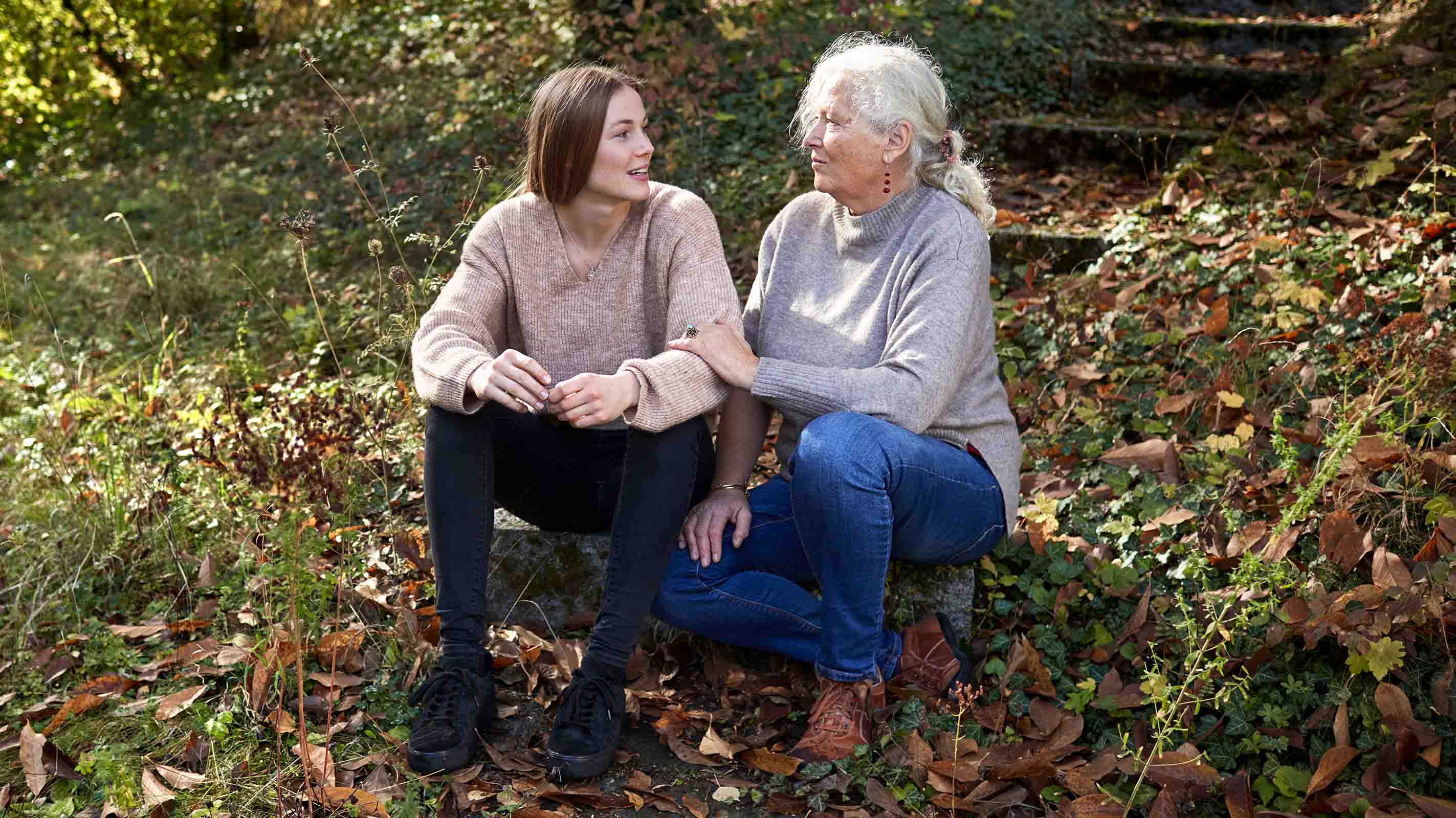 A senior woman listens closely to a younger woman.