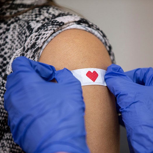 Patient receiving bandage from CVS pharmacist after vaccination