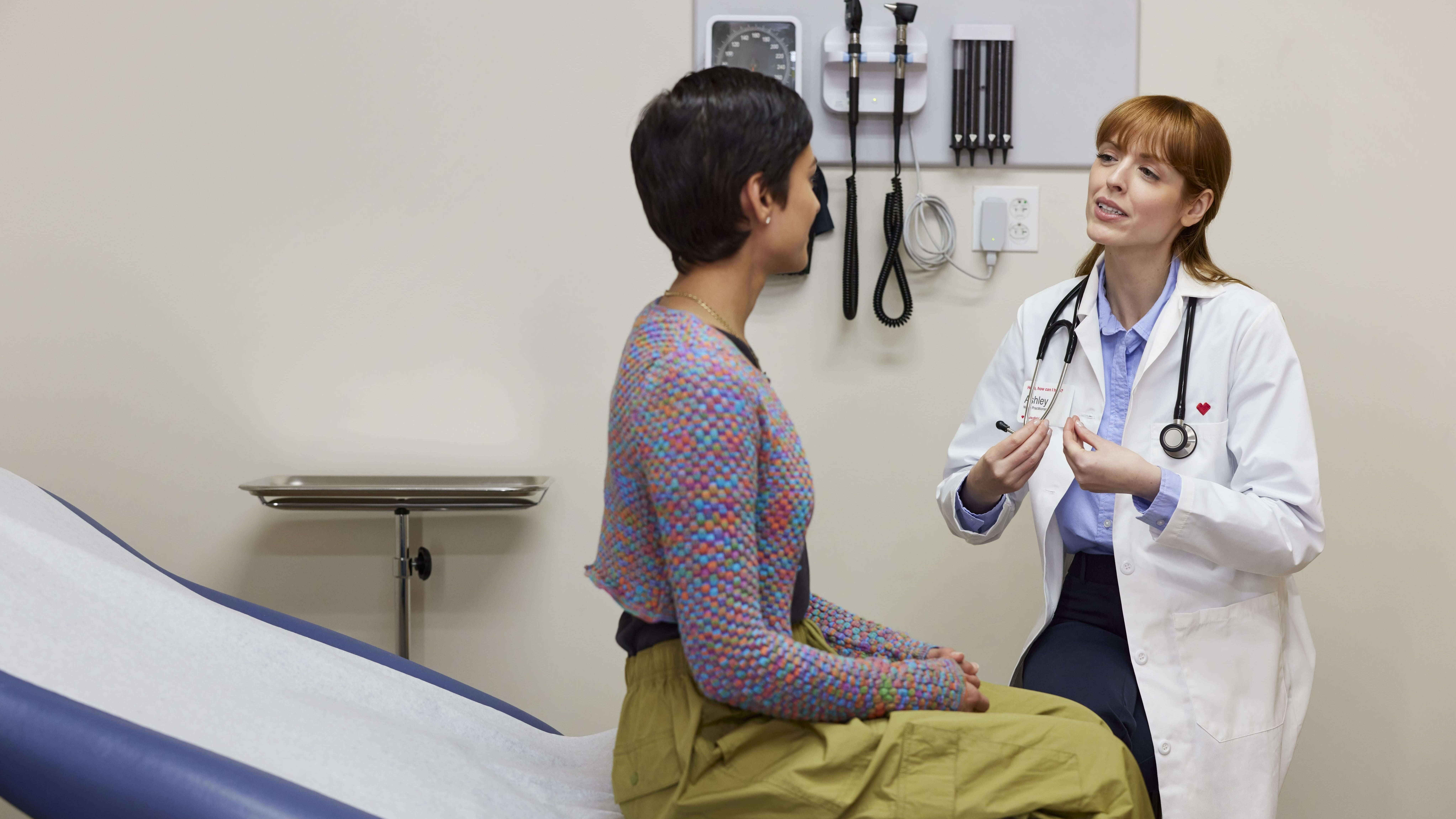 a woman health care provider and her female patient discuss period health.