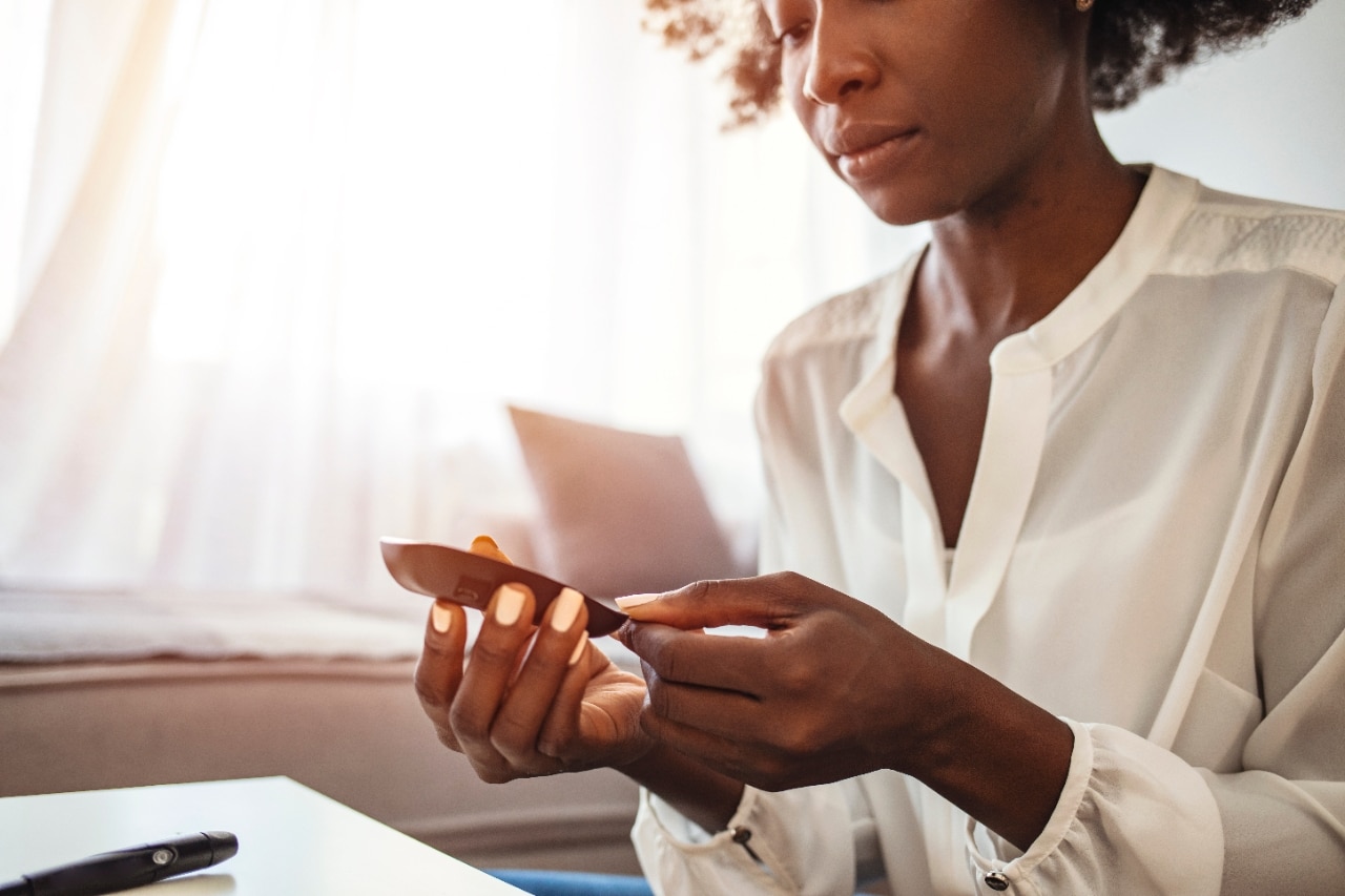 women checking her blood sugar on devices